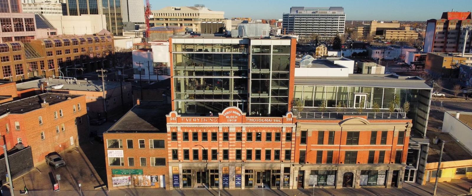 The red-brick Ernest Brown Block on Jasper Avenue in Edmonton, with a modern glass addition above. Studio Slow Form is on the second floor.